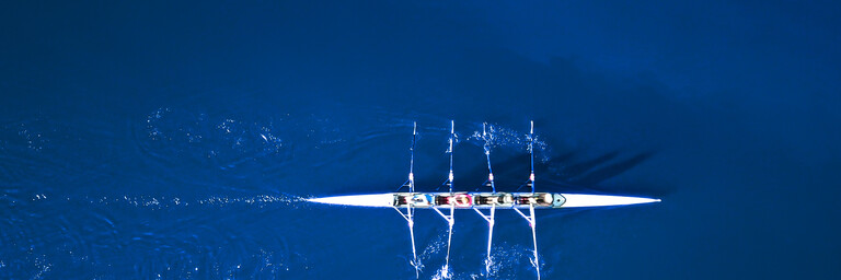 Aerial view of a rowing boat surrounded by classic blue water